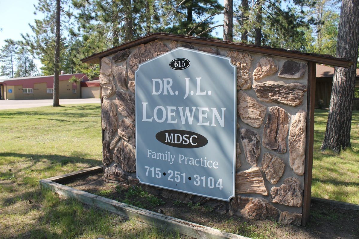 Stone sign at 615 Washington Ave reading Dr. J.L. Loewen MDSC, Family Practice, 715-251-3104
